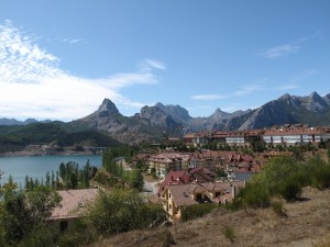 Beautiful new looking town next to a lake with mountains in the background